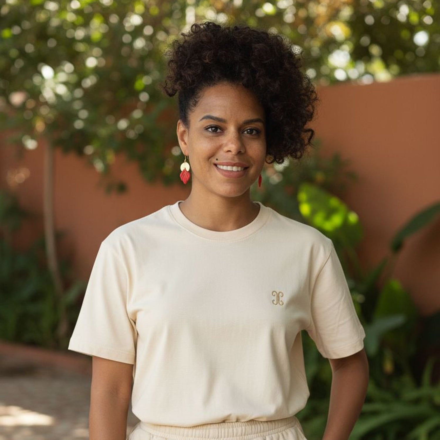 Model wearing Handmade red and gold statement earrings with polymer clay and gold accents