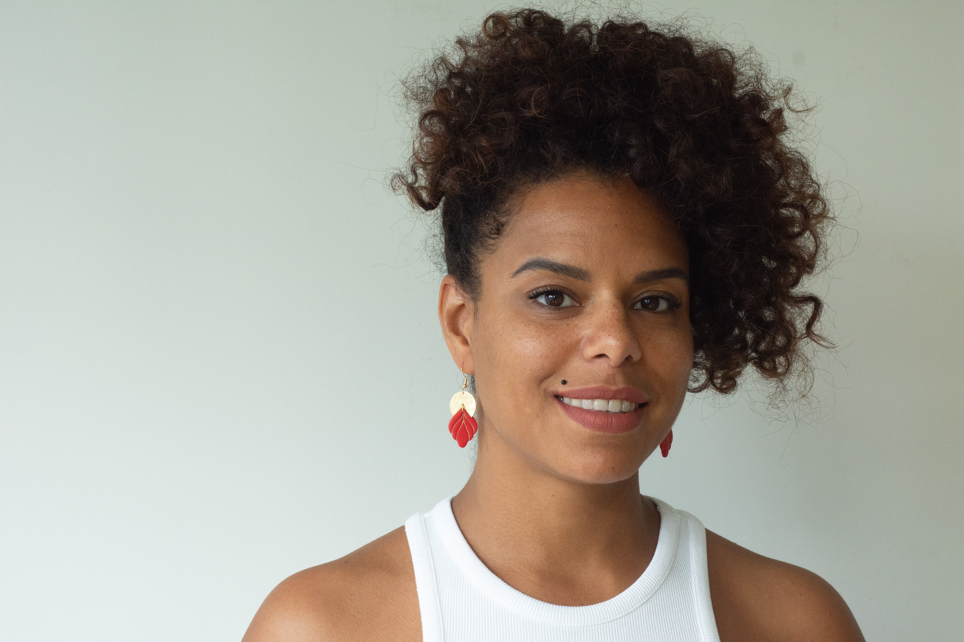 Model wearing Handmade red and gold statement earrings with polymer clay and gold accents
