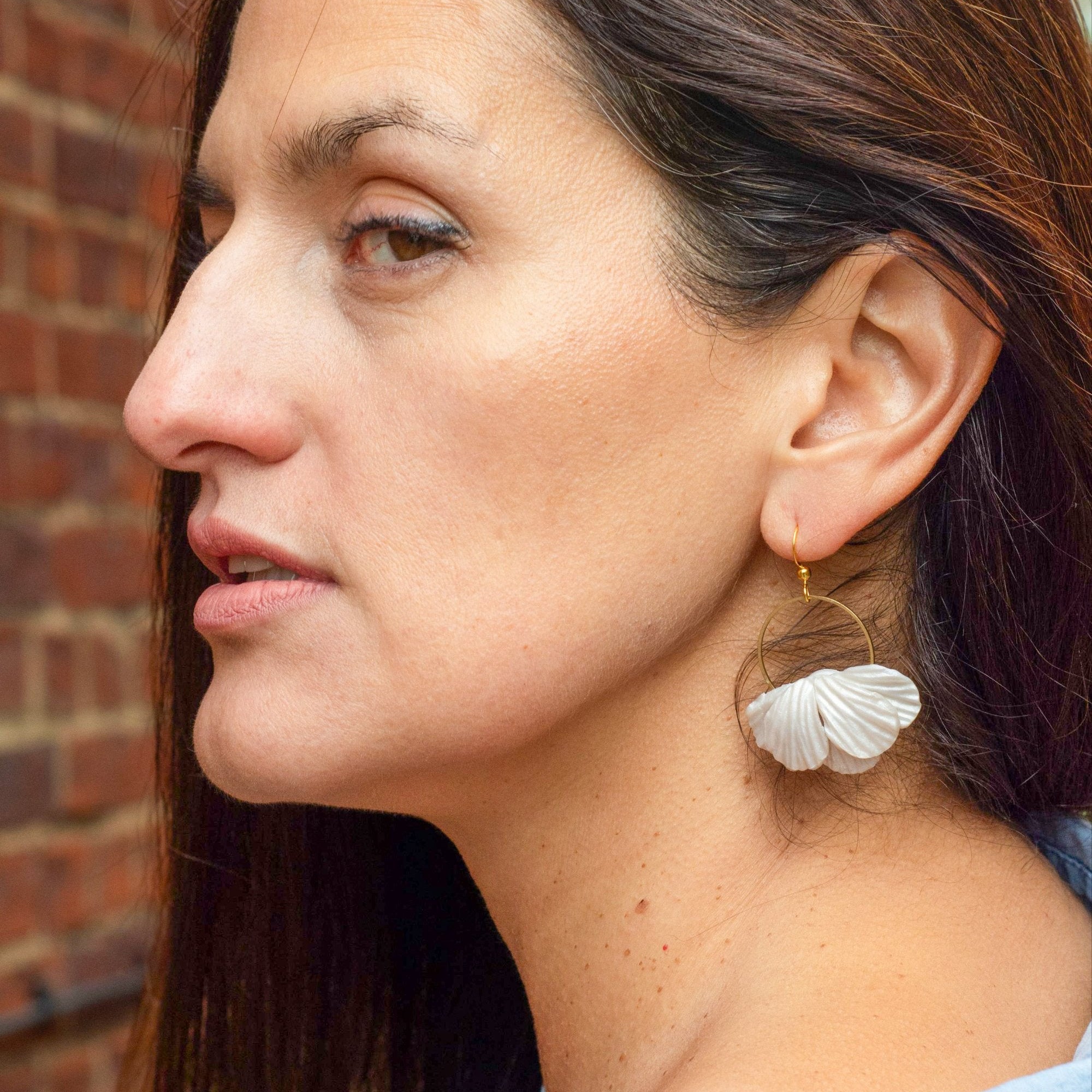 Model wearing Flower Bridal  earrings on a card with a plant in the background