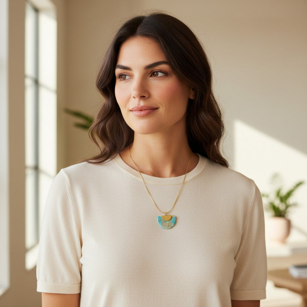 Woman wearing a blue faux stone necklace with a pendant in a bright room