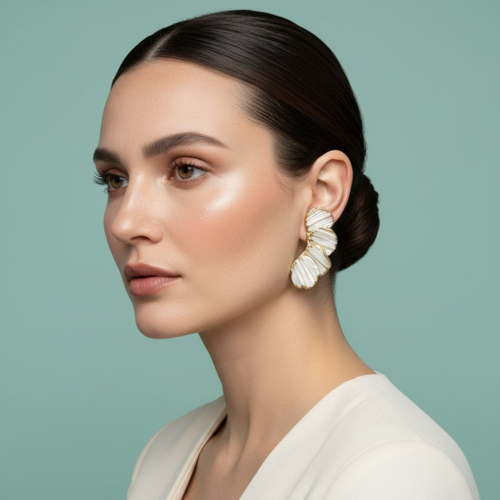 Woman wearing bridal earrings, leaf-shaped earrings against a light green background