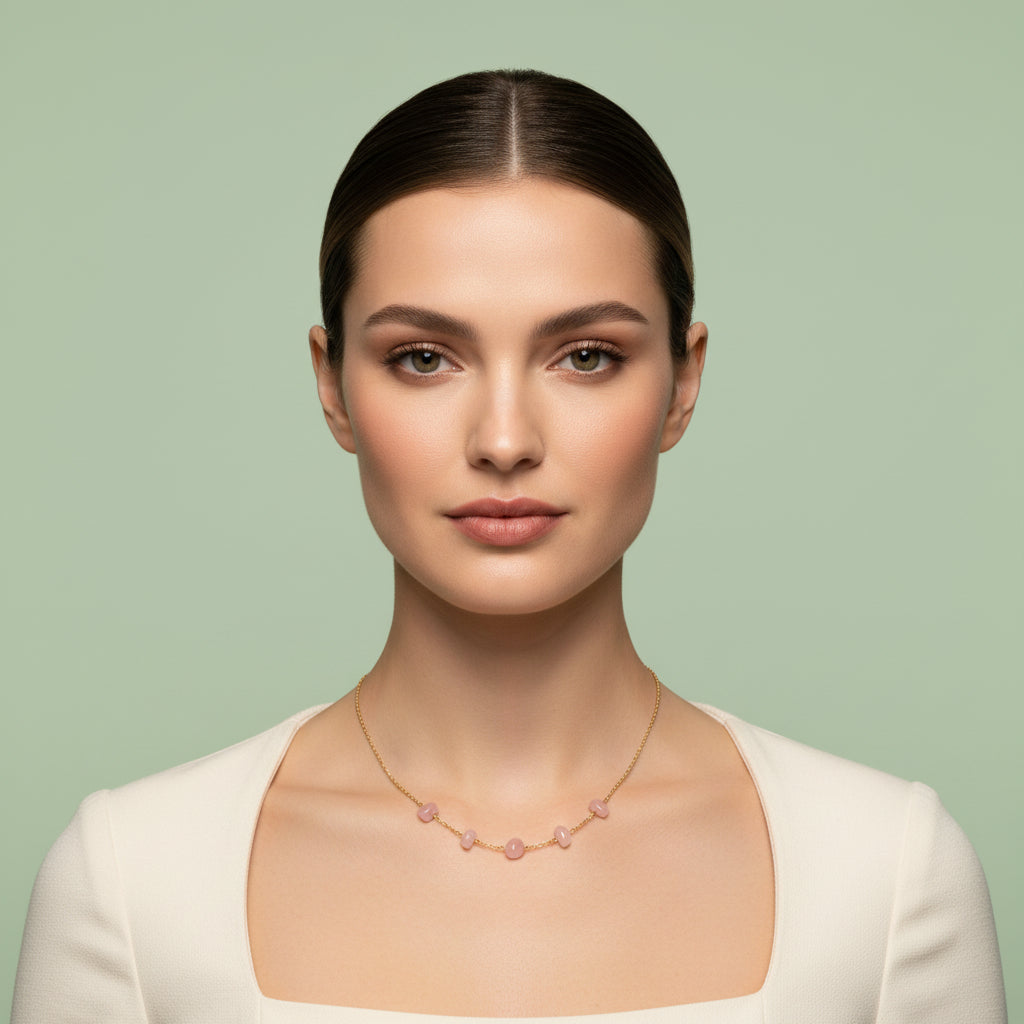 Model wearing a delicate rose quartz five-bead necklace on a gold chain, styled with a soft neutral top.