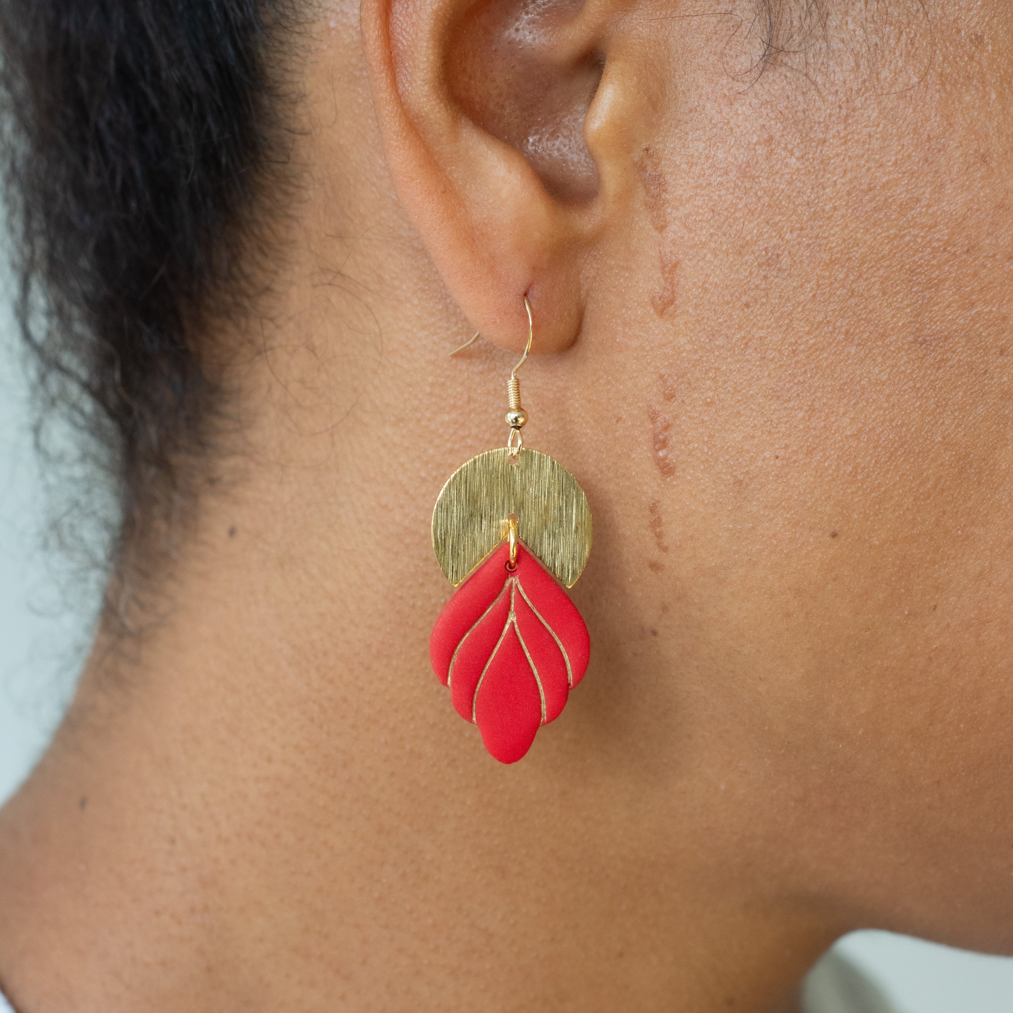Model wearing Handmade red and gold statement earrings with polymer clay and gold accents